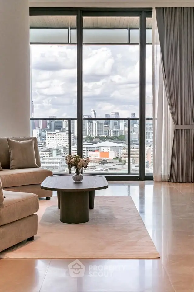 Luxurious living room with stunning city view from large windows, elegant decor and cozy seating.