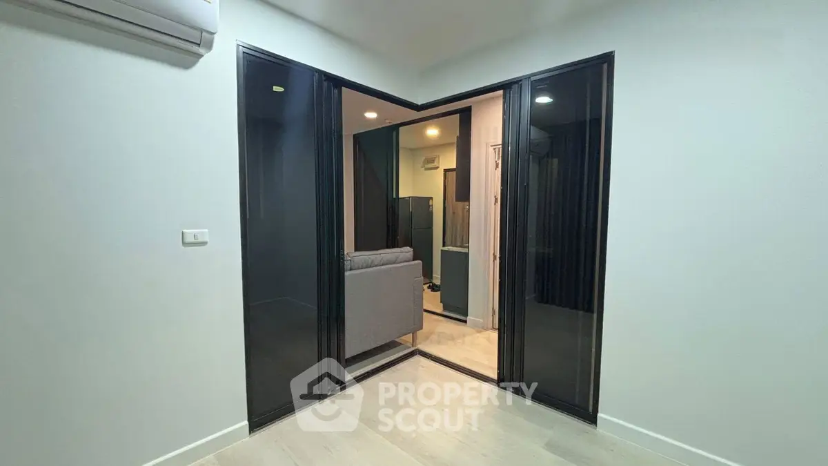 Modern interior with sliding glass doors and cozy living area, perfect for urban living.