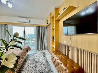 Modern living room with balcony view, large TV, and stylish decor.