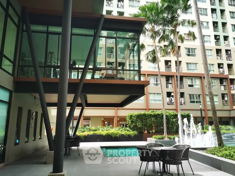 Modern condominium exterior with pool and lush greenery
