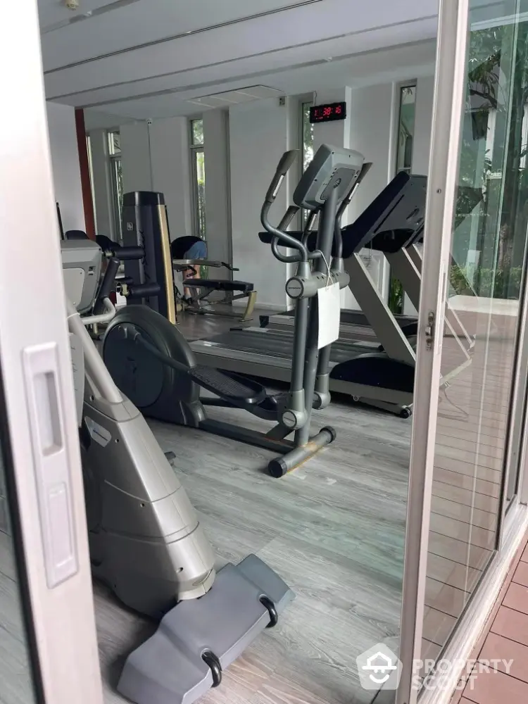 Modern gym with state-of-the-art fitness equipment and large windows for natural light.