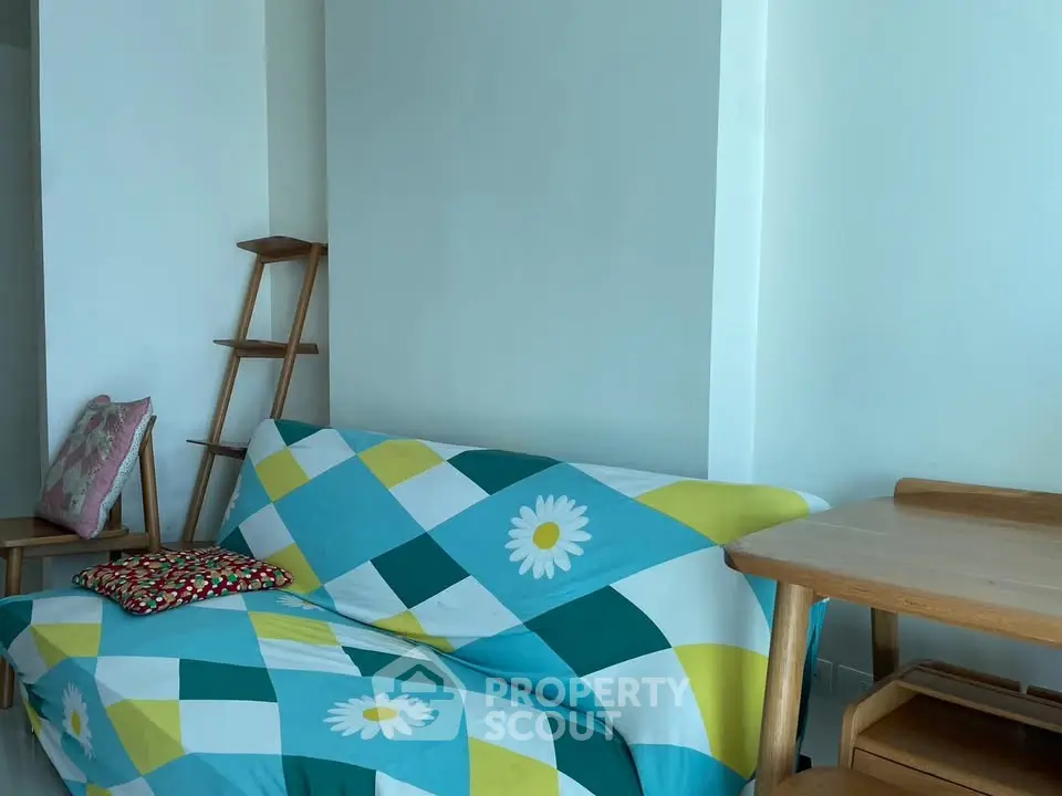 Cozy living room with colorful sofa and wooden furniture, perfect for relaxation.