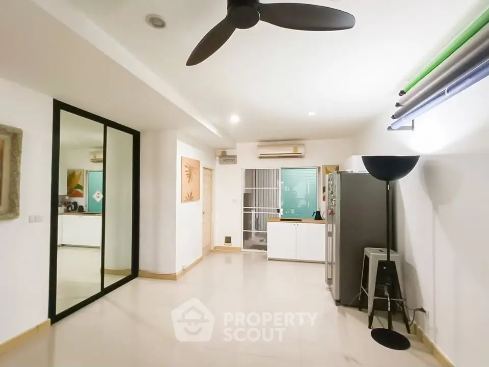 Spacious modern living area with sleek design and ceiling fan