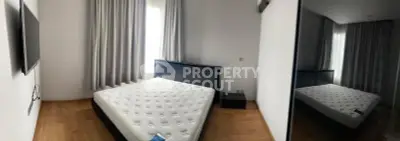 Spacious bedroom with modern decor and large window for natural light.