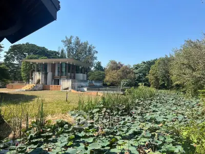 Modern architectural home with lush garden and serene pond view