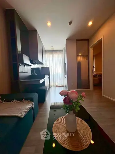 Modern living room with stylish decor and open layout, featuring a cozy seating area and elegant lighting.