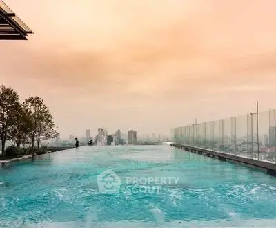 Stunning rooftop infinity pool with breathtaking city skyline view at sunset.