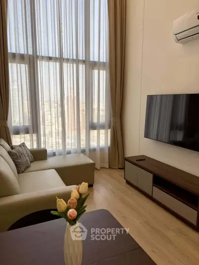 Modern living room with high ceilings, large windows, and stylish furniture.