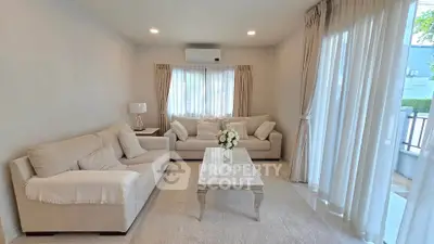 Elegant living room with cozy sofas and natural light, perfect for relaxation.