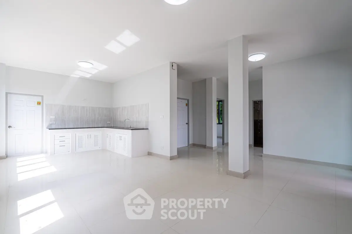 Spacious open-plan living area with modern kitchen and ample natural light.