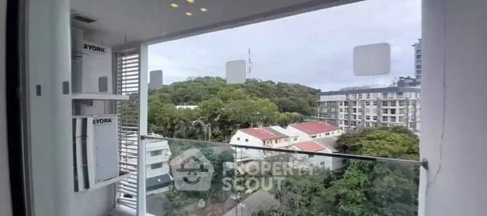 Stunning balcony view overlooking lush greenery and cityscape, perfect for urban living.