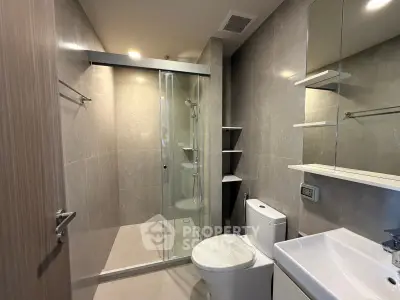 Modern bathroom with sleek shower and elegant fixtures in a contemporary apartment.