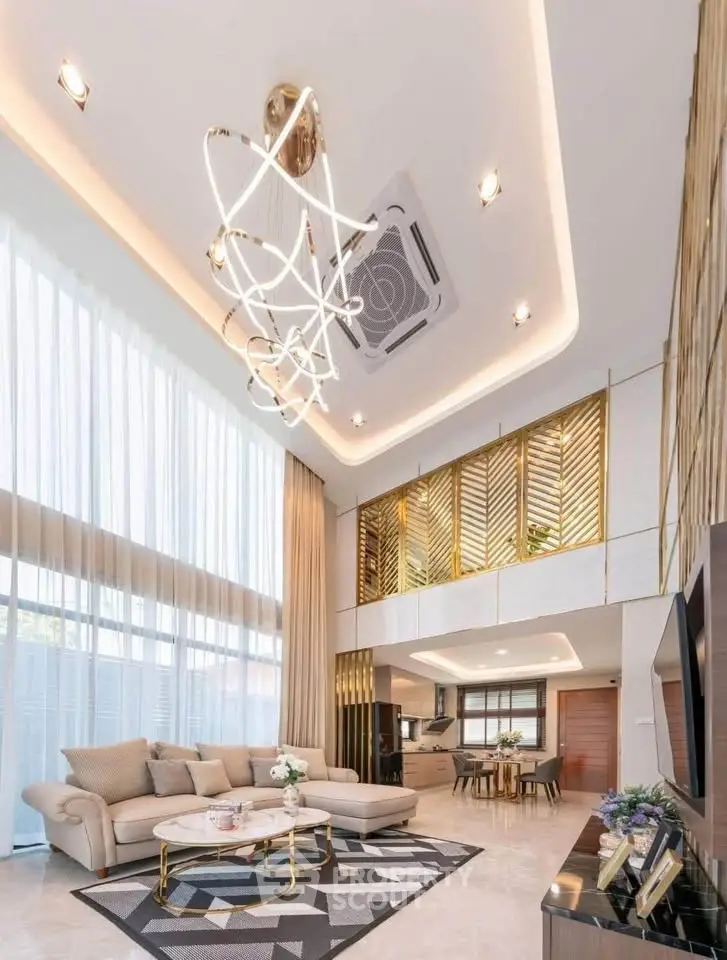 Luxurious modern living room with high ceilings and elegant chandelier in open-concept layout.