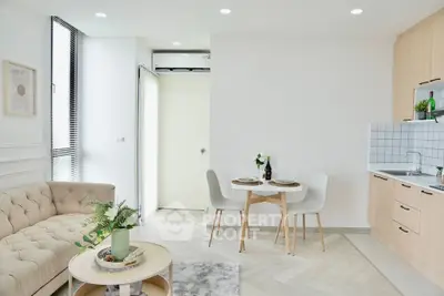 Modern living room with cozy sofa, dining area, and stylish kitchen in open layout apartment.