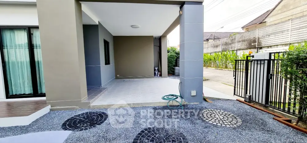 Spacious modern home exterior with covered patio and gated entrance