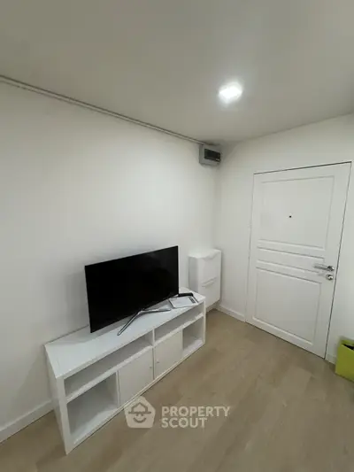 Modern minimalist living room with sleek TV setup and white decor