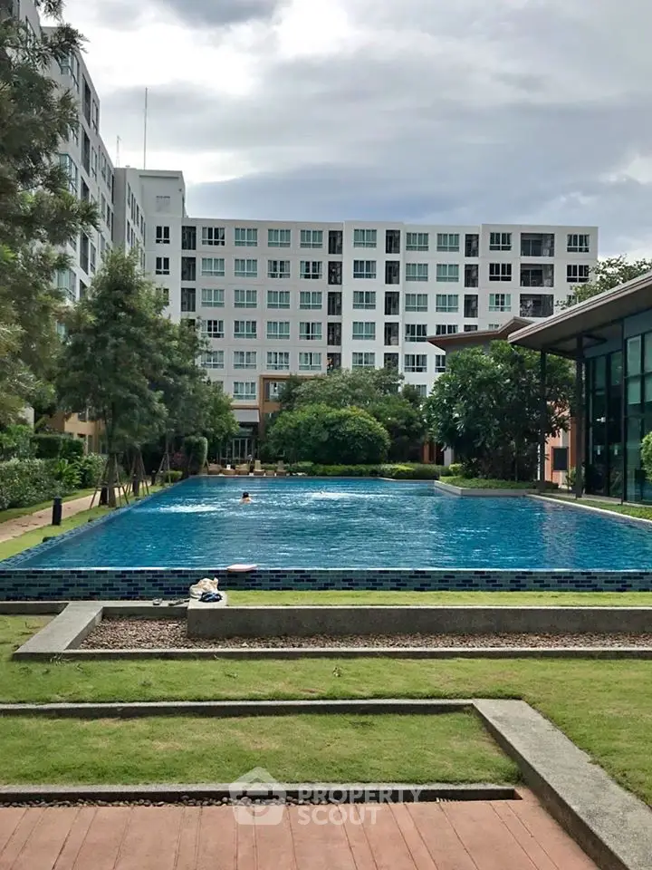 Luxurious residential building with a stunning pool and lush greenery, perfect for relaxation and leisure.