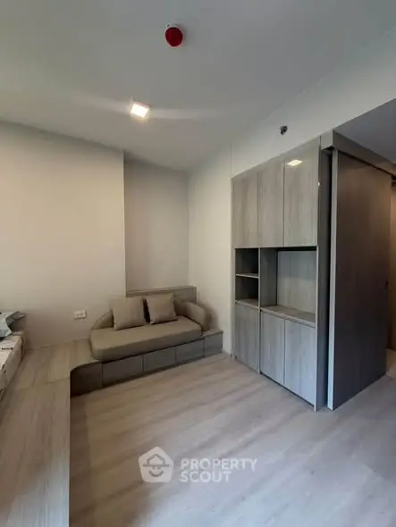Modern living room with sleek built-in storage and cozy seating area, perfect for urban living.