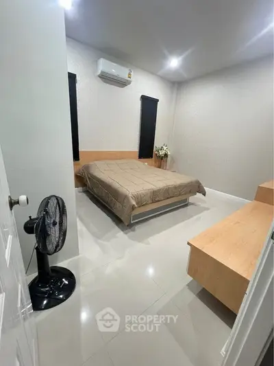 Modern bedroom with sleek design, featuring a comfortable bed, air conditioning, and minimalist decor.