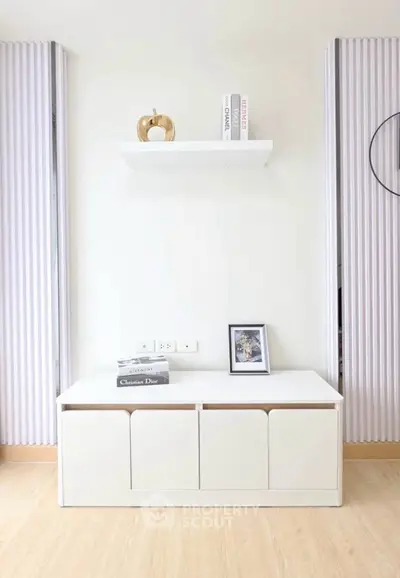 Modern minimalist living room with sleek white furniture and decorative accents.