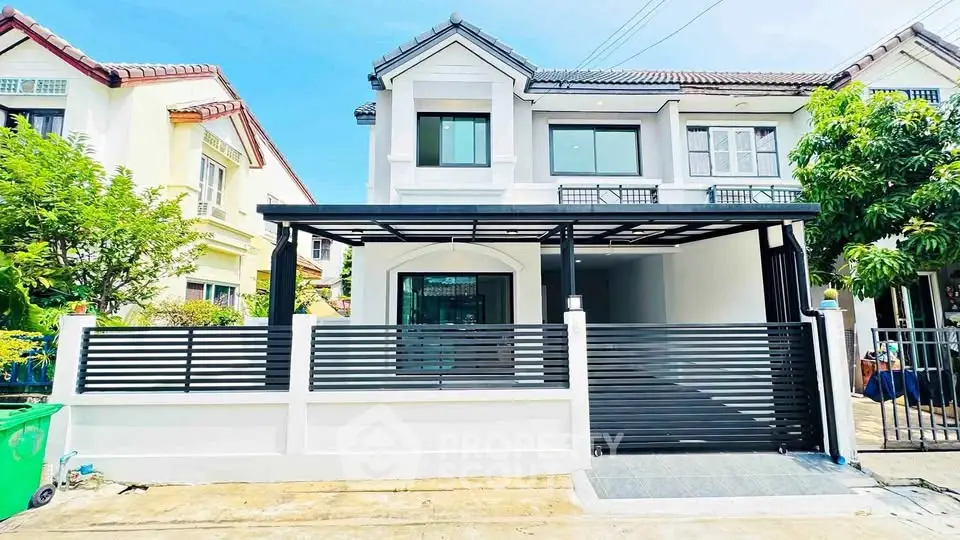 Charming two-story house with modern facade and gated driveway in a serene neighborhood.