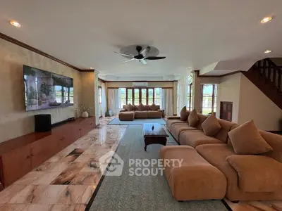 Spacious living room with plush seating and large windows offering natural light.