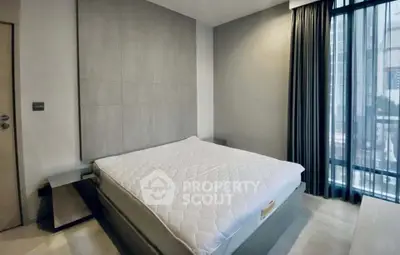 Modern bedroom with large window and stylish decor in urban apartment