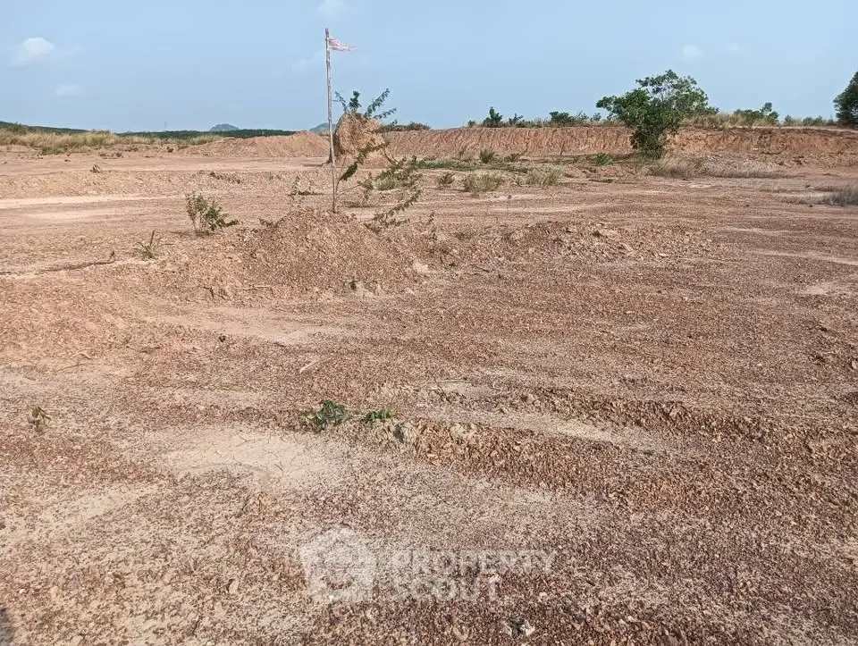 Expansive land plot with potential for development, featuring open terrain and clear skies.