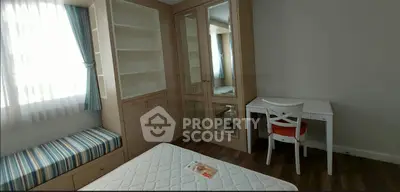 Cozy bedroom with built-in wardrobe, study desk, and window seat in modern apartment.