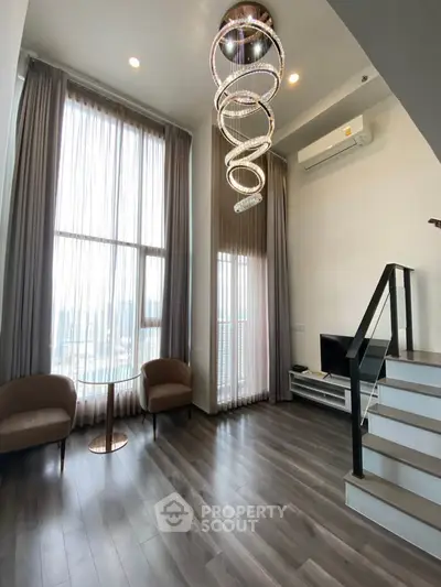 Luxurious high-ceiling living room with modern chandelier and elegant decor