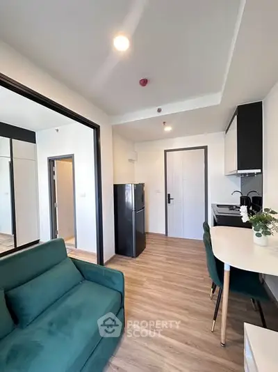 Modern apartment interior with open kitchen and cozy living area, featuring sleek design and contemporary furnishings.