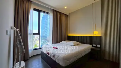Modern bedroom with large window and city view, featuring stylish lighting and contemporary decor.