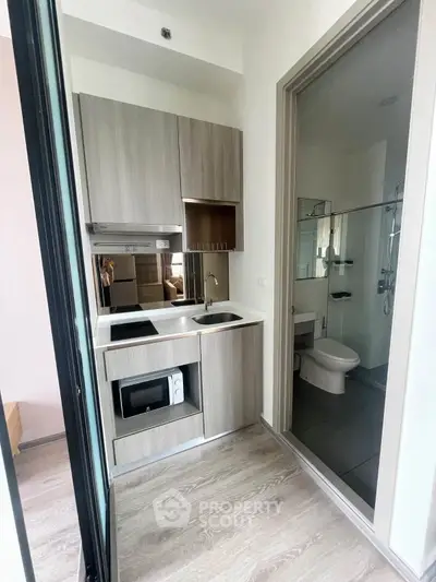 Modern compact kitchen with sleek cabinetry and integrated appliances in a stylish apartment.