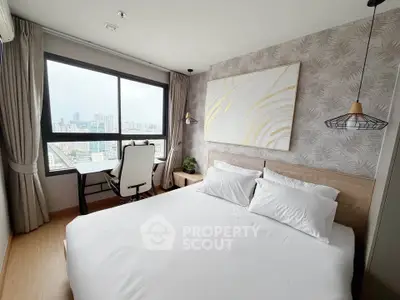 Modern bedroom with city view, featuring stylish decor and a cozy workspace by the window.