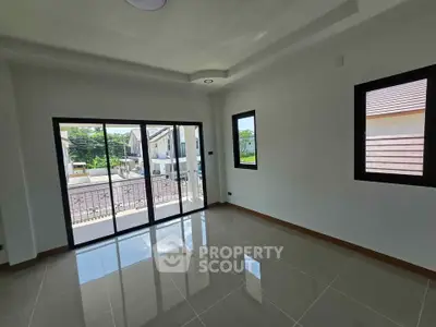 Spacious empty room with large windows and balcony access in modern home