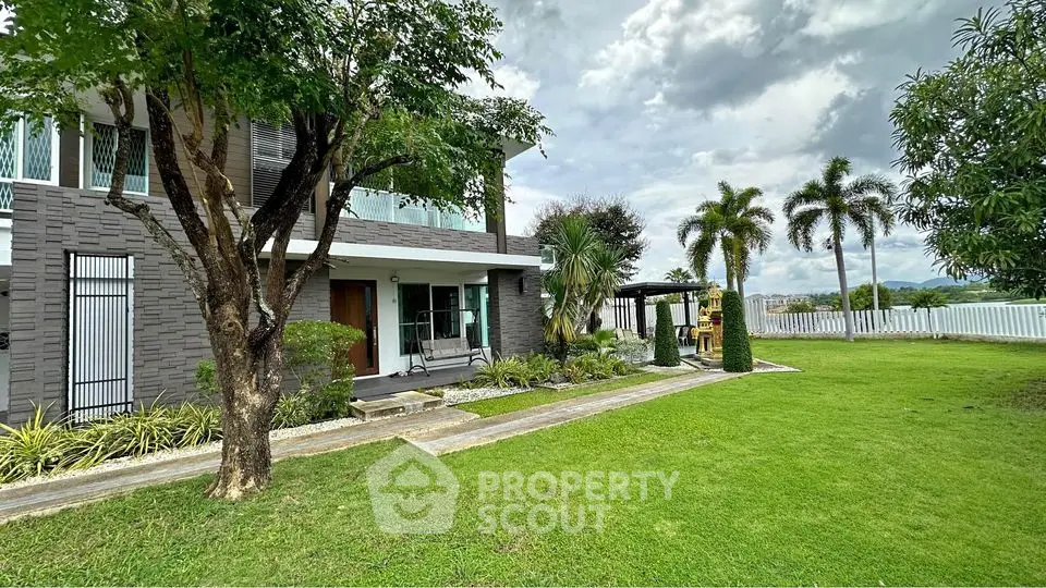 Stunning modern home with lush garden and spacious lawn, perfect for outdoor living.