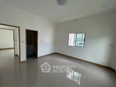 Spacious unfurnished room with glossy tiled floor and natural light