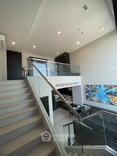 Modern duplex apartment with stylish staircase and vibrant wall art