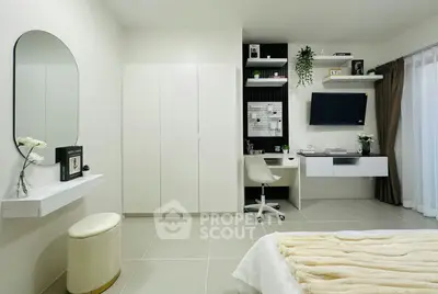 Modern bedroom with sleek design, featuring a study area, wall-mounted TV, and elegant decor.