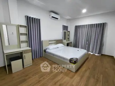Spacious modern bedroom with elegant wooden flooring and stylish furnishings.