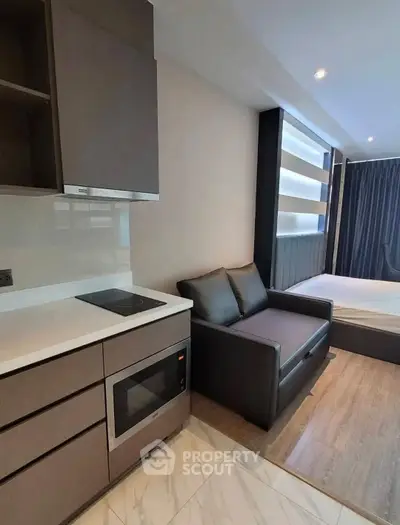 Modern studio apartment with sleek kitchen and cozy living area