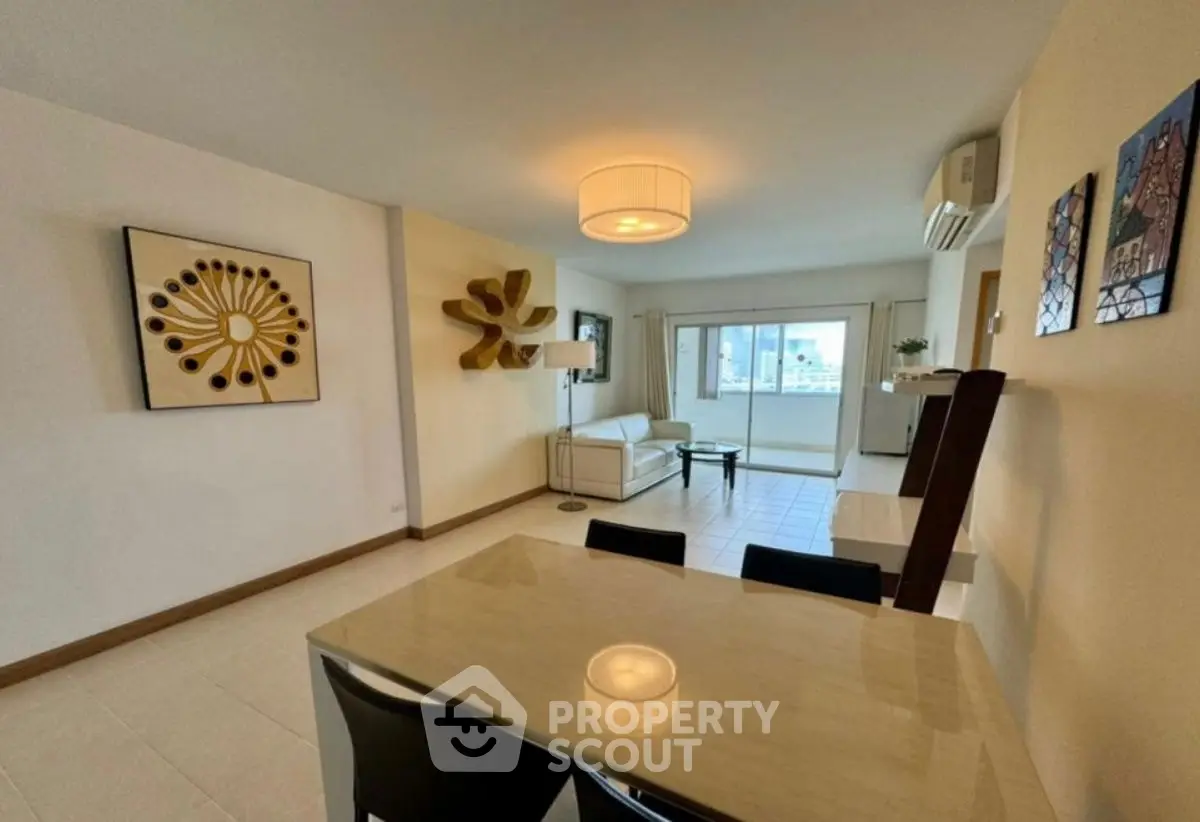 Spacious living room with modern decor and large windows offering city views.