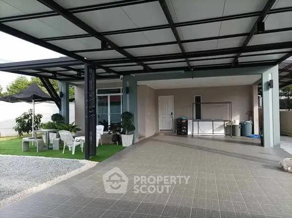 Spacious modern carport with outdoor seating and greenery, perfect for relaxation.