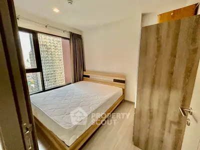 Modern bedroom with large window and wooden furniture in urban apartment