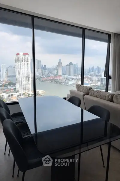 Luxurious high-rise apartment with stunning city and river views from the dining area.