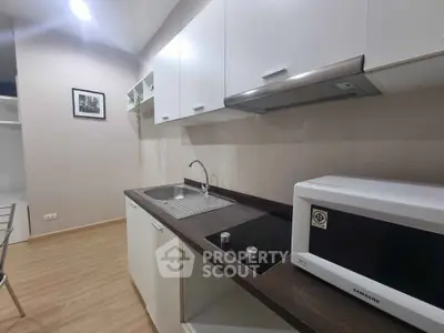 Modern kitchen with sleek cabinets and built-in appliances in a stylish apartment.