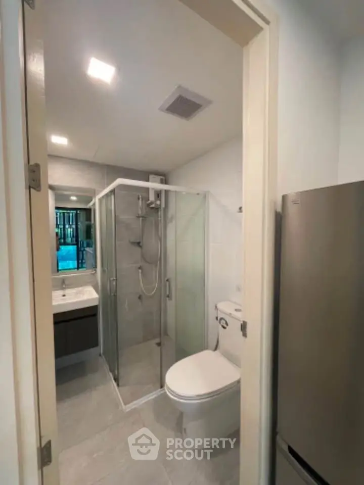 Modern bathroom with glass shower and sleek fixtures in a contemporary apartment.