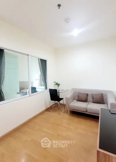 Cozy living room with wooden flooring and modern furniture in a bright apartment.