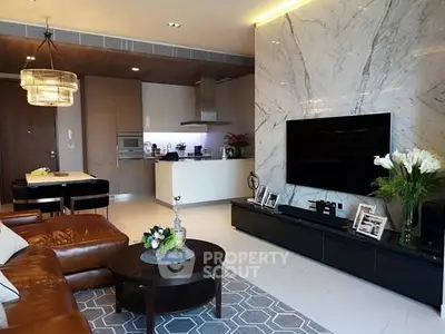 Luxurious modern living room with marble accent wall and open kitchen layout.