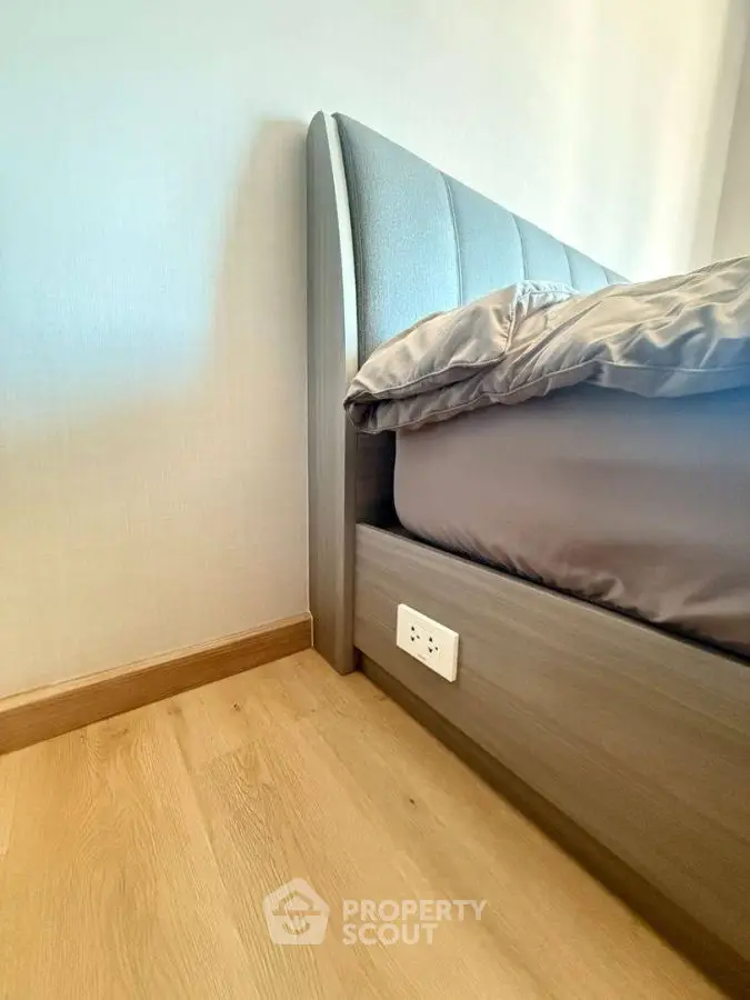 Modern bedroom corner with stylish bed and wooden flooring